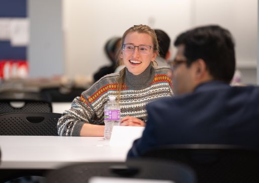 A female medical student sitting at a table smiling