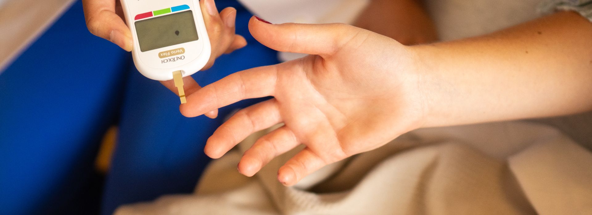 Closeup photo of an endocrinologist using a strip device to check a patient's blood sugar