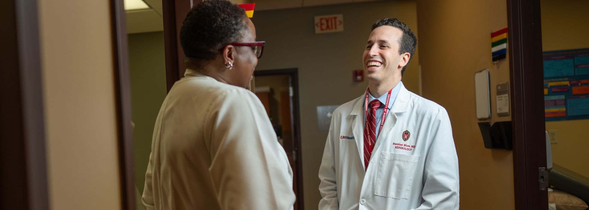 Dr. Matthew Blum and Amaka Achufusi laugh together in a clinic hallway