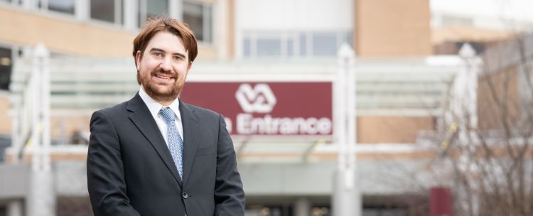 Dr. Aaron Kuntz stands in front of the VA