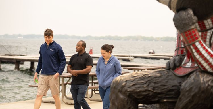 Graduating 2024 internal medicine residents Zak Scherzer, MD, Habib Kedir, MD, and Alaina Kelly, MD, enjoy a walk by Lake Mendota.