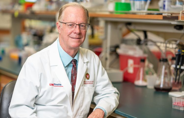 Dr. Allan Brasier in a white lab coat in his lab