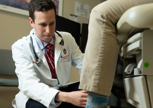 Dr. Matthew Blum examines a patient's leg in the dialysis clinic